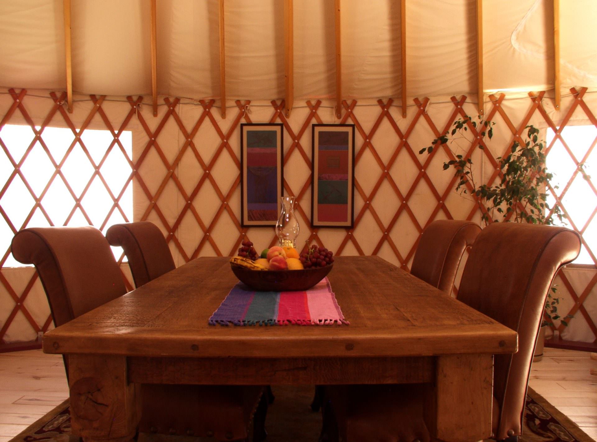 Elegant yurt dining space with chandelier and panoramic window views